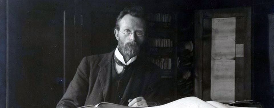 Image: LA30/PH/325. Portrait photograph of Eoin MacNeill seated at a desk with an open book. © University College Dublin, National University of Ireland, Dublin, and Lafayette Ltd (original image).